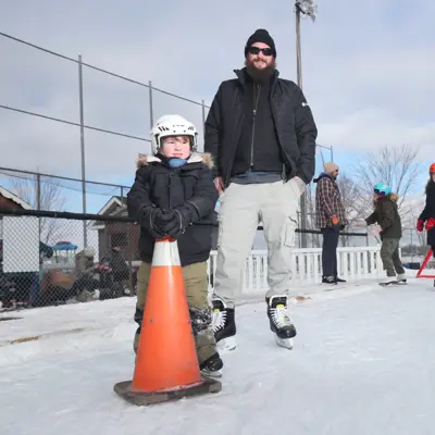 Father and child on outdoor skating rink