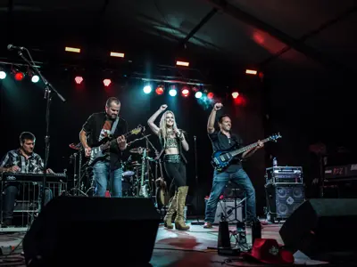 band performing on black stage with colourful lights in background