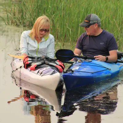 two people in kayaks talking on Nonquon River