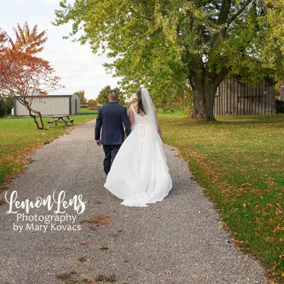 photo from the rear of newlyweds walking down path at Scugog Shores Museum