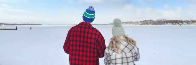 Man and Woman facing frozen Lake Scugog from Palmer Park shore