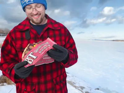 man smiling and looking down at Beavertail pastry in his hands