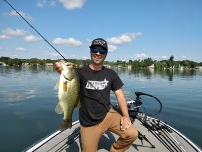 person on fishing boat in lake holding fish