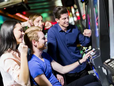 friends testing their luck on slot machine at Great Blue Heron Casino